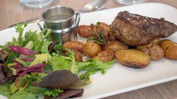 A plate with roasted meat, potatoes, and a salad.