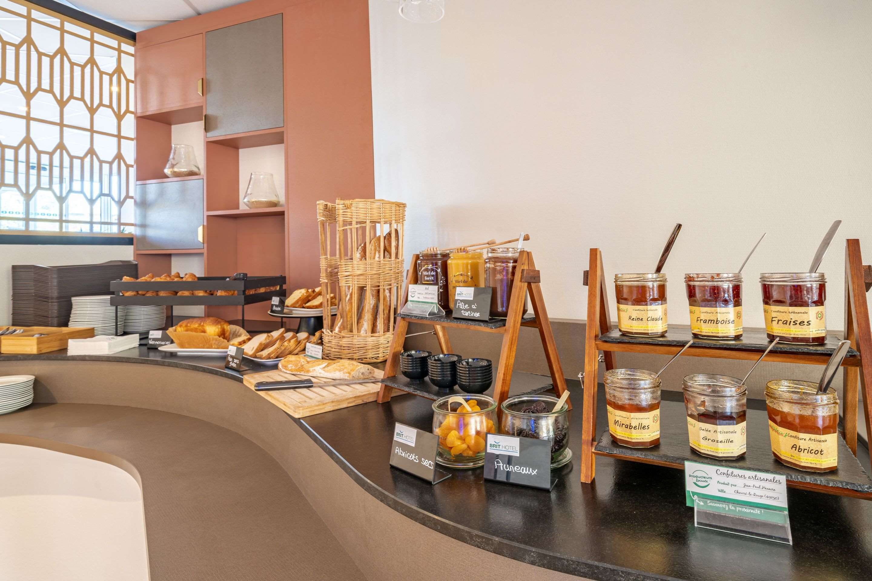 Een ontbijtbuffet met diverse gebakjes, brood en jam.
