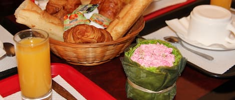 A breakfast tray with croissants, juice, and a wrapped gift.