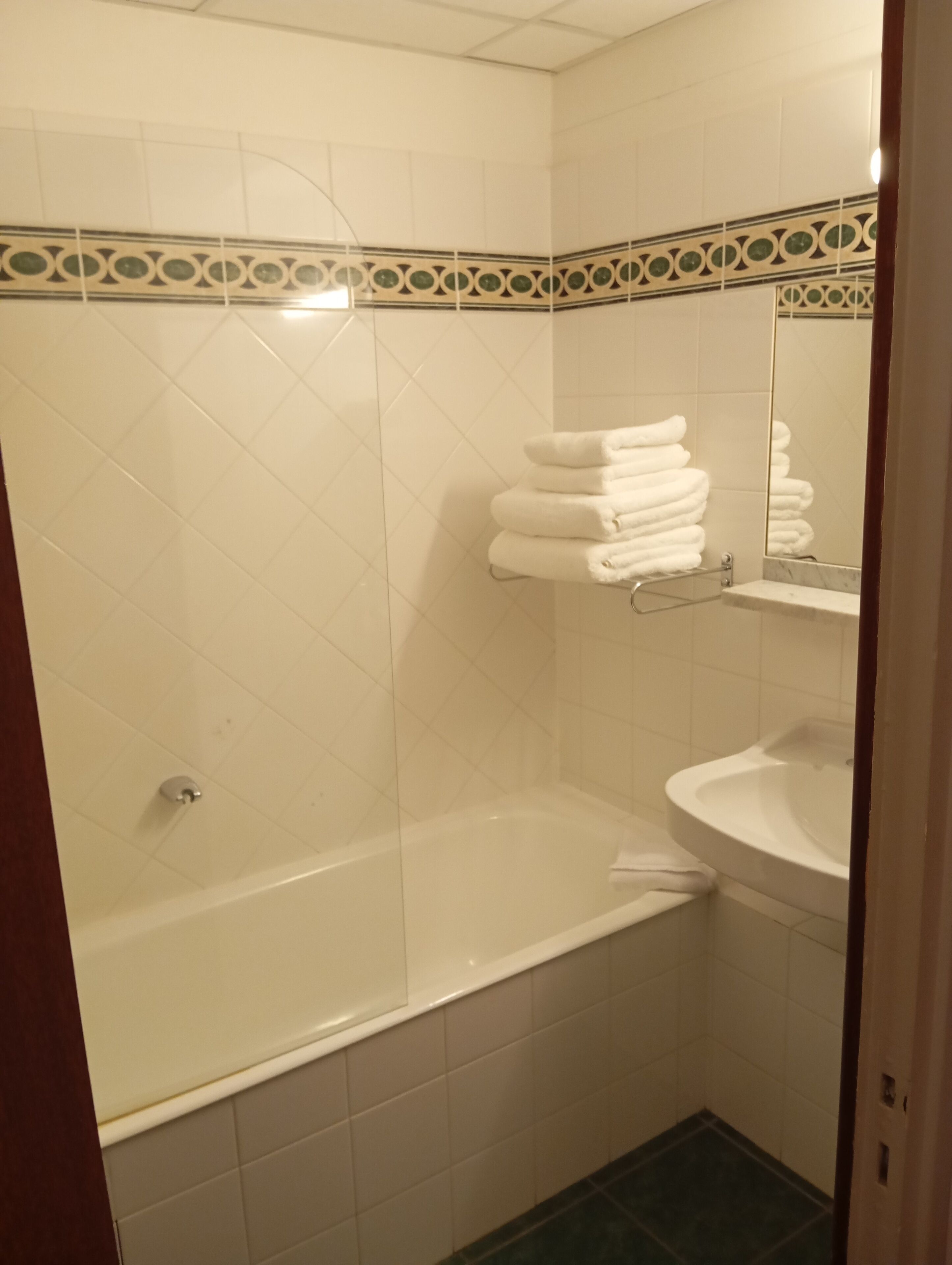 A bathroom with a bathtub, a sink, and a towel rack.