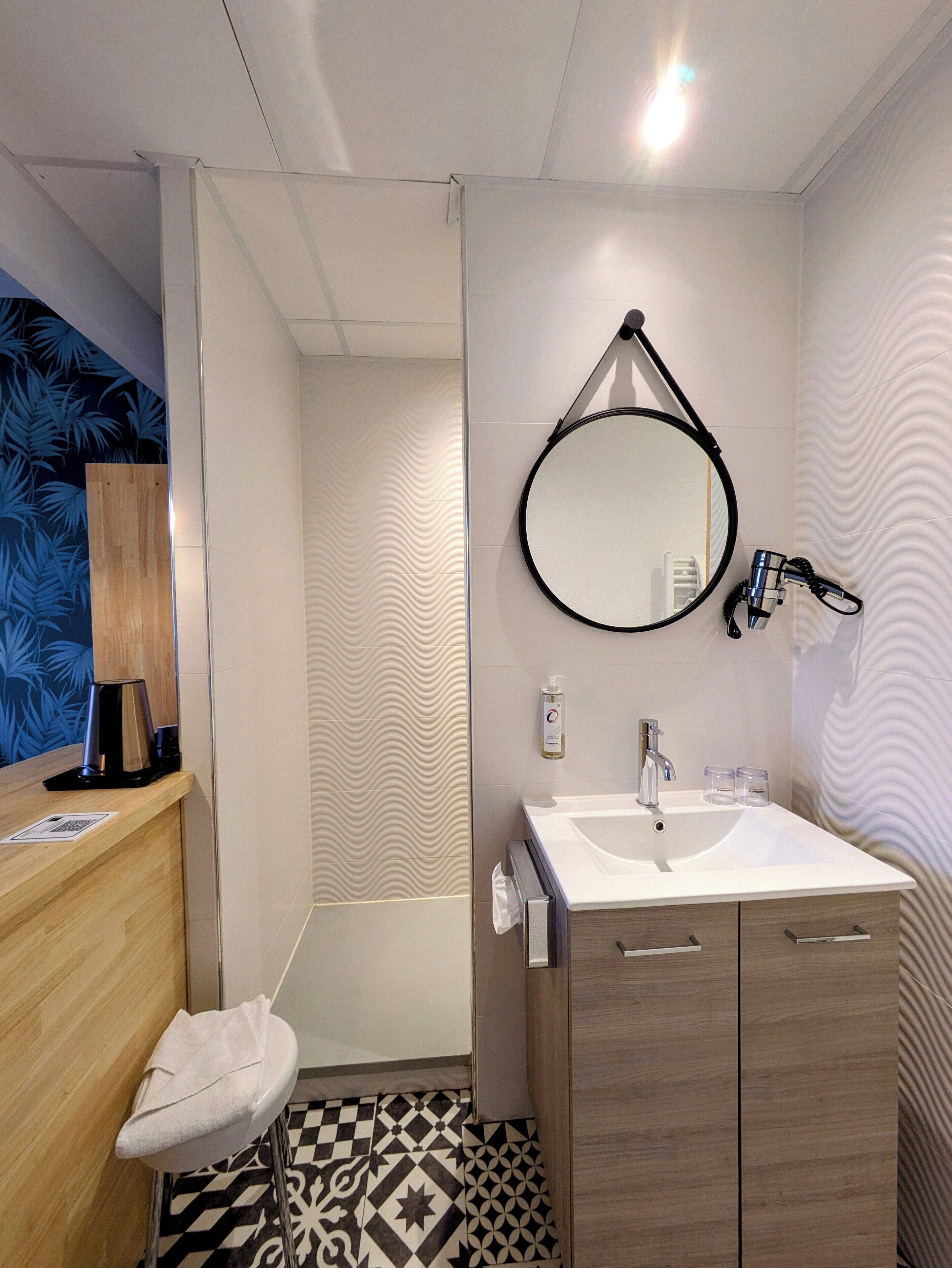 Een moderne badkamer met een wastafel, spiegel en handdoekhouder.