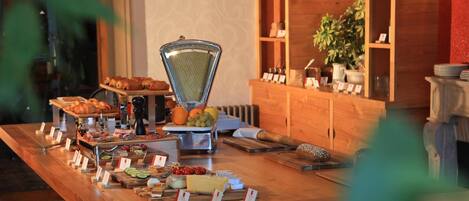 Mesa de buffet con distintos alimentos y un rallador.