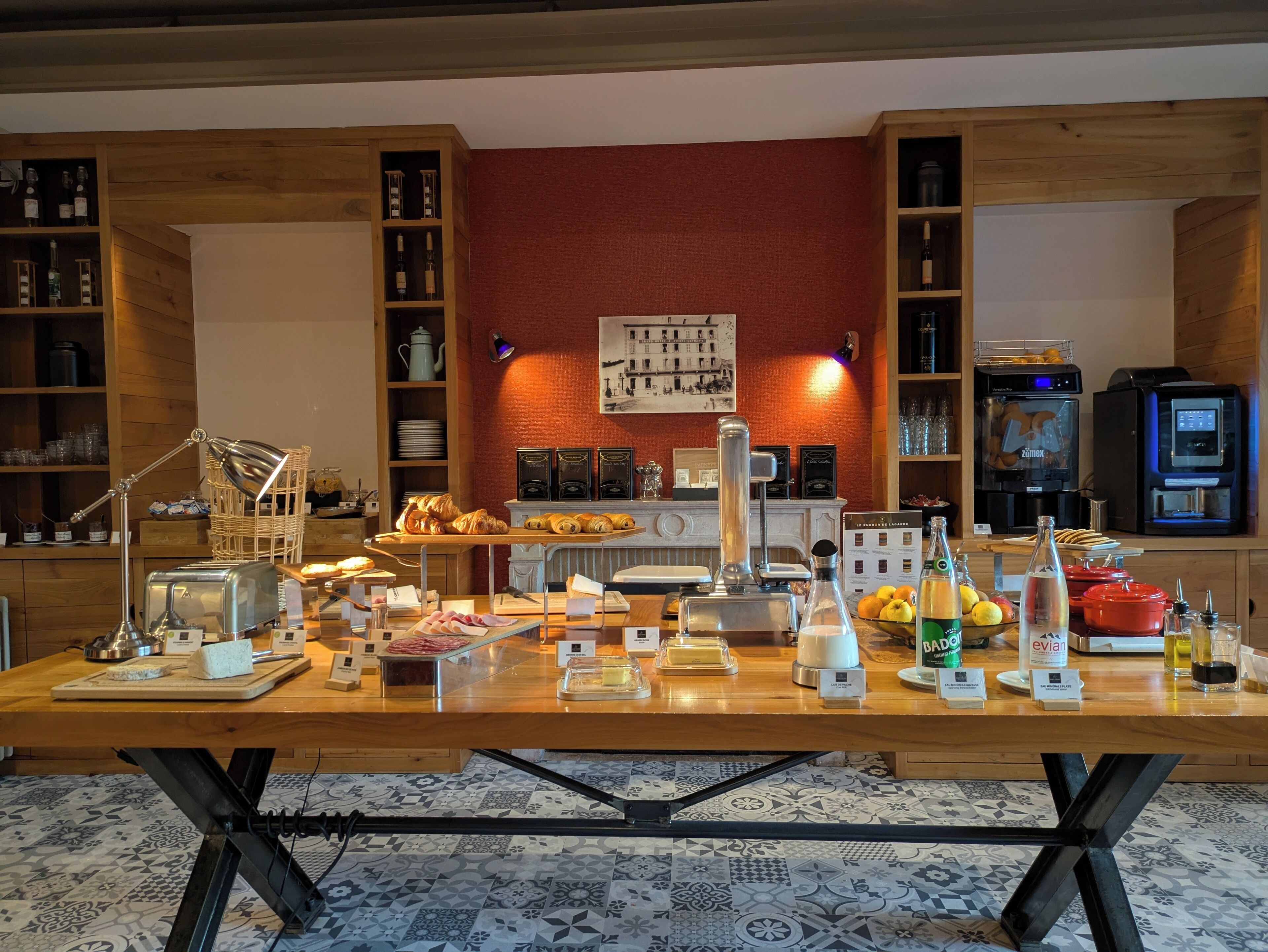 A breakfast buffet with various food items, a coffee machine, and a wine cooler.