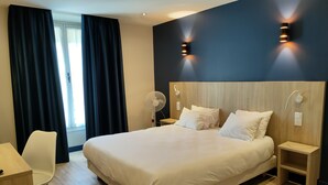 A modern hotel room with a large bed, bedside tables, a desk, and a chair. - Hotel Modern'Est (Paris)