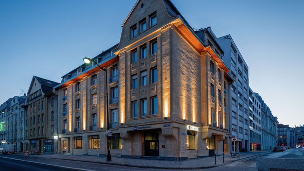 Un edificio d'angolo su più piani, con ampie finestre e un ingresso ben visibile.