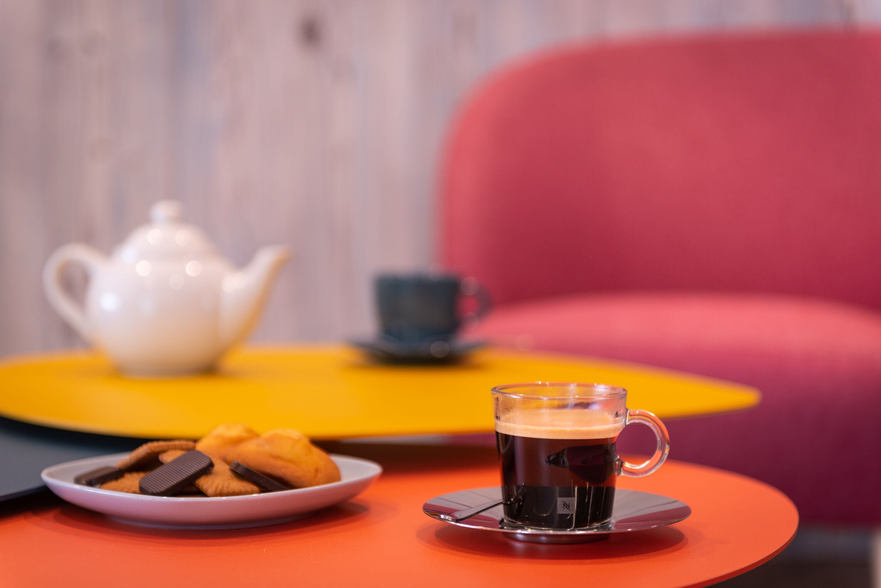 Ein Tisch mit einer Tasse Kaffee und einem Teller Kekse.
