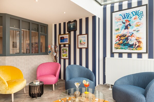 A room with striped walls, a large poster, and three chairs. - Hôtel de la Plage (Dieppe)