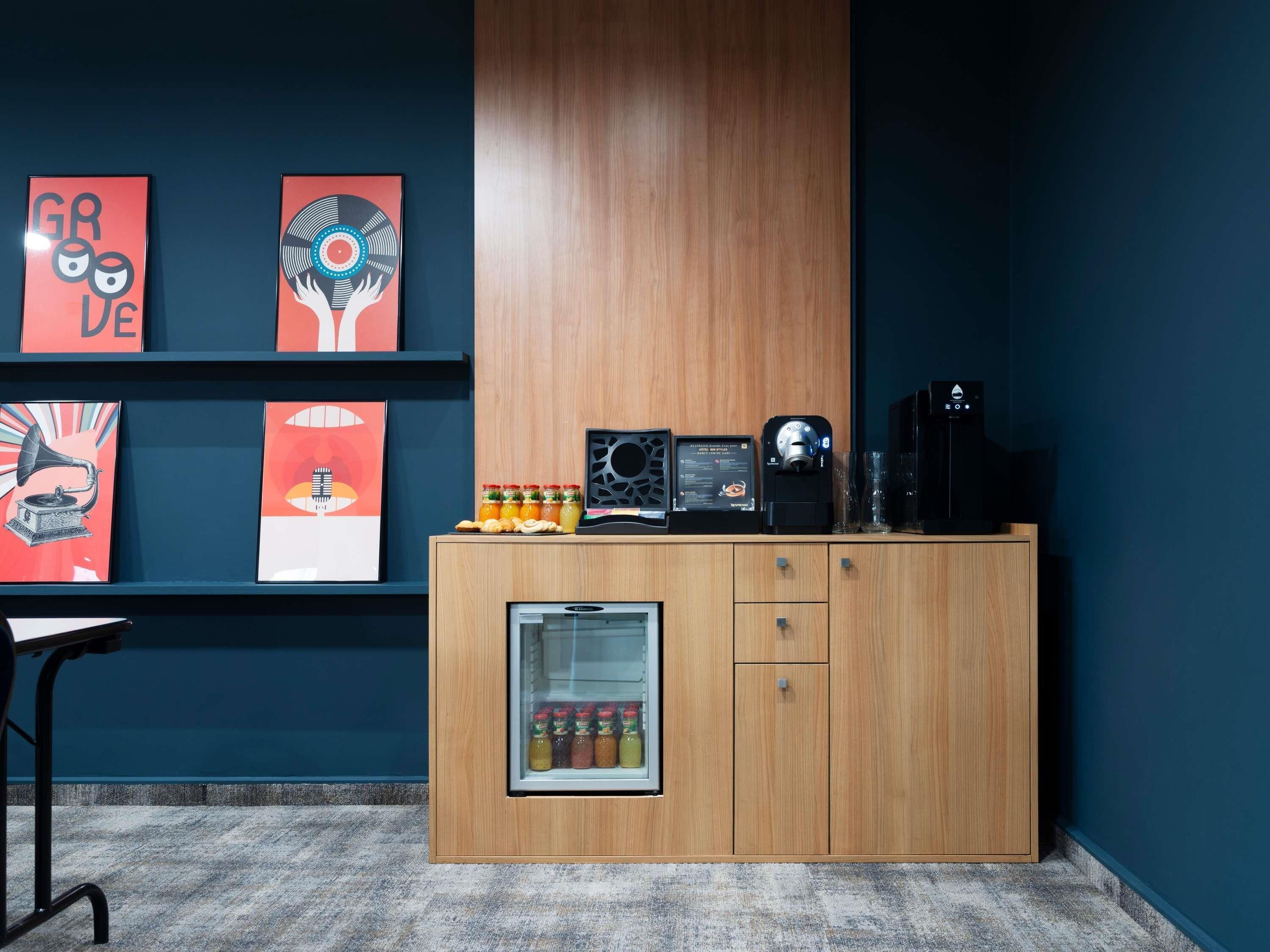 A modern room with a wooden cabinet, a coffee machine, and a refrigerator.