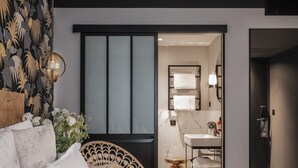 Un dormitorio moderno con cama, un diseño decorativo en la pared y vistas al baño.