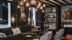 Una sala de estar moderna con un sofá oscuro, sillones a cuadros, una mesa de centro y una chimenea.