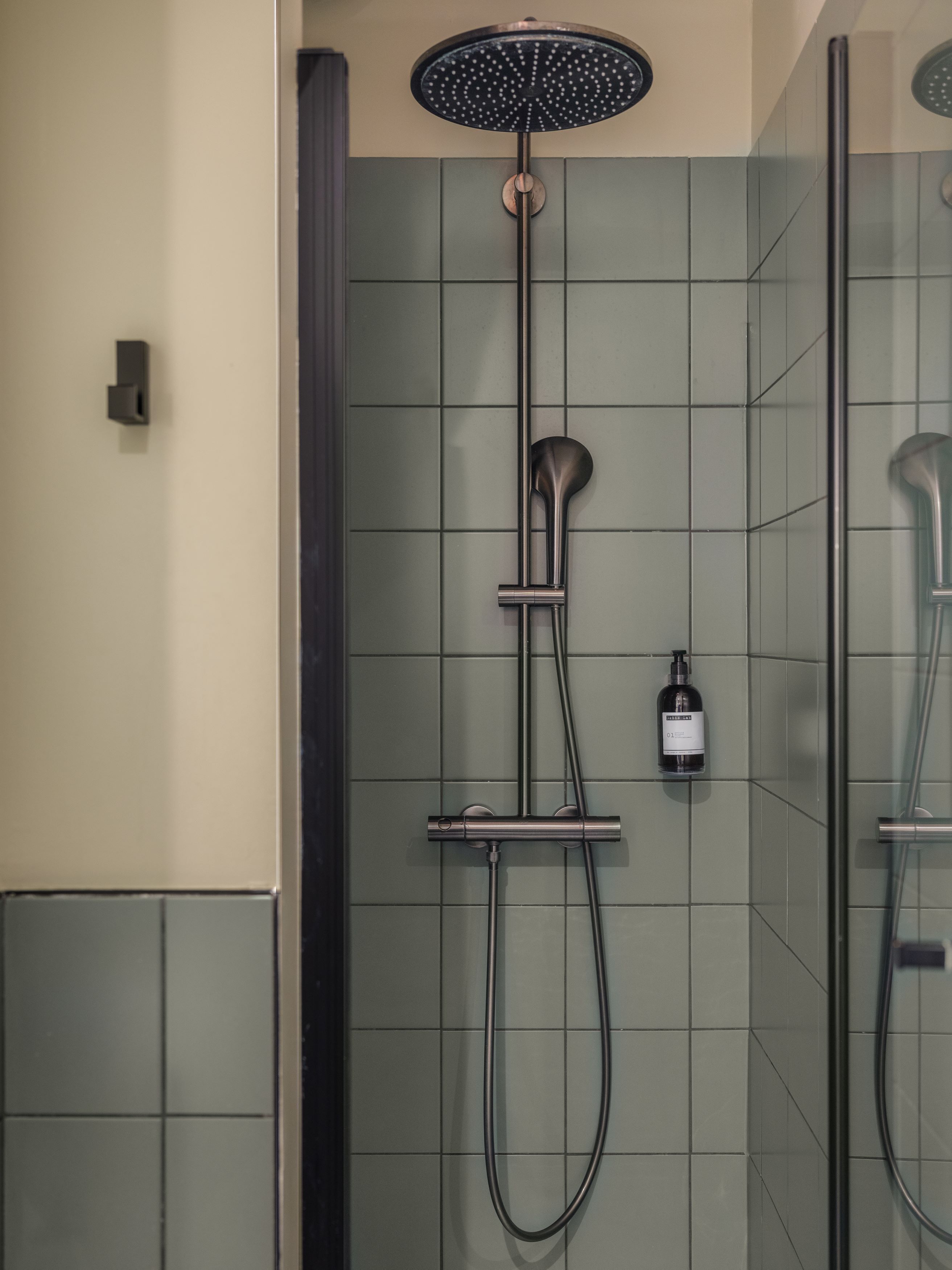 Een douche met een handdouche en een apart handmatige douchespuit.