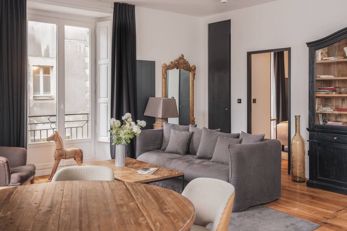 A modern living room with a grey sofa, a wooden coffee table, and a lamp.