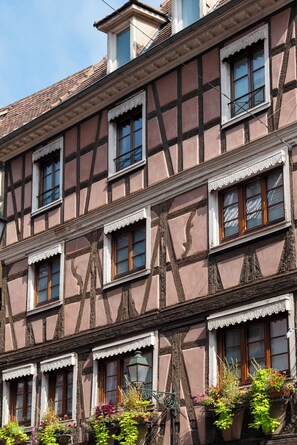 Un edificio tradicional con entramado de madera, varias ventanas y balcones.