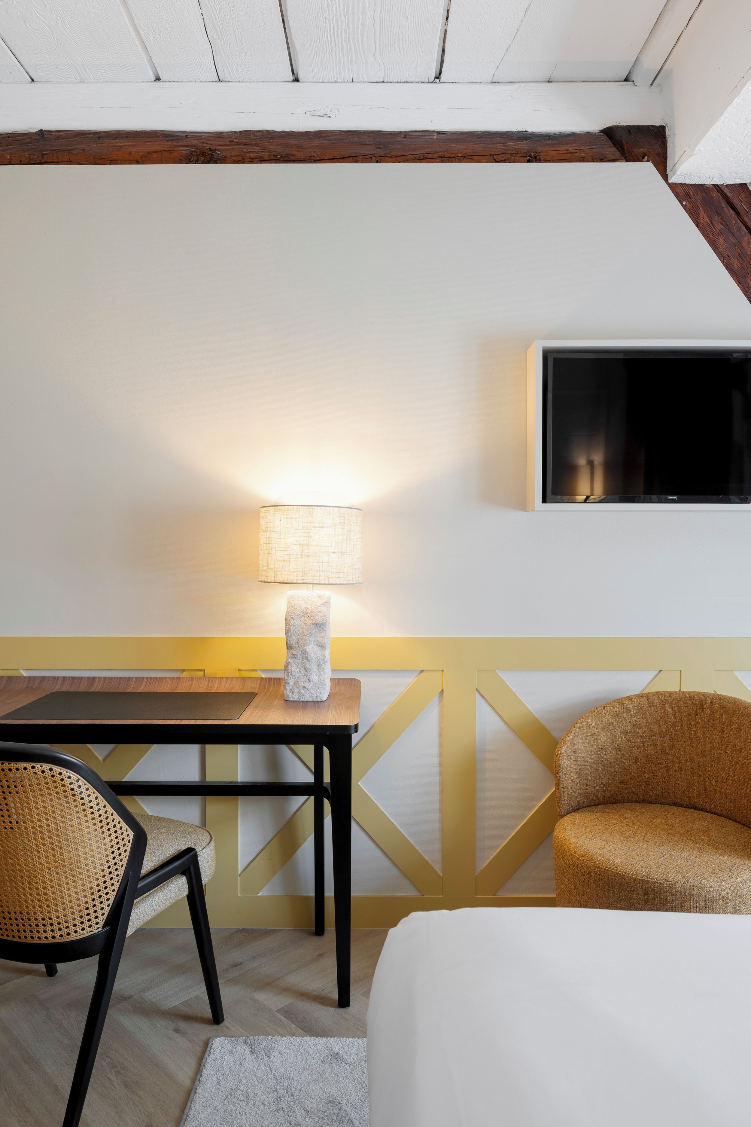 Une pièce comprenant un lit, une table avec une lampe, une chaise et un canapé.
