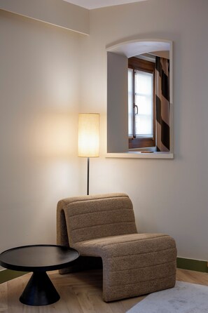 A modern room with a sofa, a small round table, and a floor lamp. - Hôtel de l'Europe by Happyculture (Strasbourg)