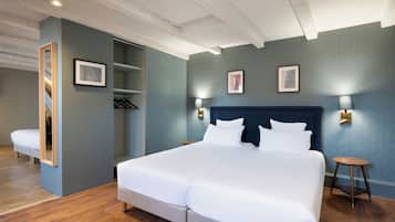 Ein Hotelzimmer mit einem großen Bett, einem Kleiderschrank, einem Spiegel und einem kleinen Tisch.