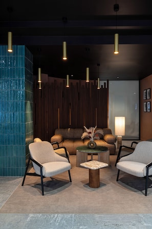 A modern lounge area with a sofa set, two armchairs, a coffee table, and pendant lighting. - Maison Boisart by Happyculture (Strasbourg)