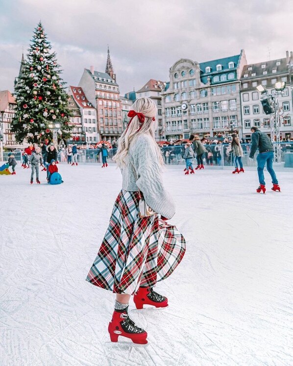 A person ice skating in a snowy outdoor area with buildings in the background. - Hôtel de l'Europe by Happyculture (Strasbourg)