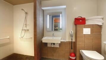 Ein Badezimmer mit Dusche, Waschbecken, Toilette und einer roten Tasche, die an der Wand hängt.