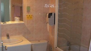 Une salle de bain équipée d’un lavabo, de toilettes et d’une douche à parois de verre.