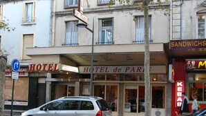 Un hôtel avec une enseigne indiquant « HÔTEL de PARIS » et un snack avec une enseigne lumineuse.