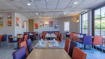 A restaurant with multiple tables and booths, equipped with white tableware and chairs.