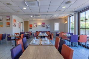 A restaurant with multiple tables and booths, equipped with white tableware and chairs. - Hotel Espace Cité (Carcassonne)