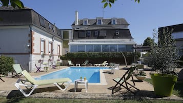 Una piscina al aire libre, tumbonas