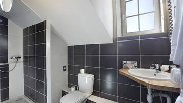 A modern bathroom with a shower, toilet, and sink.