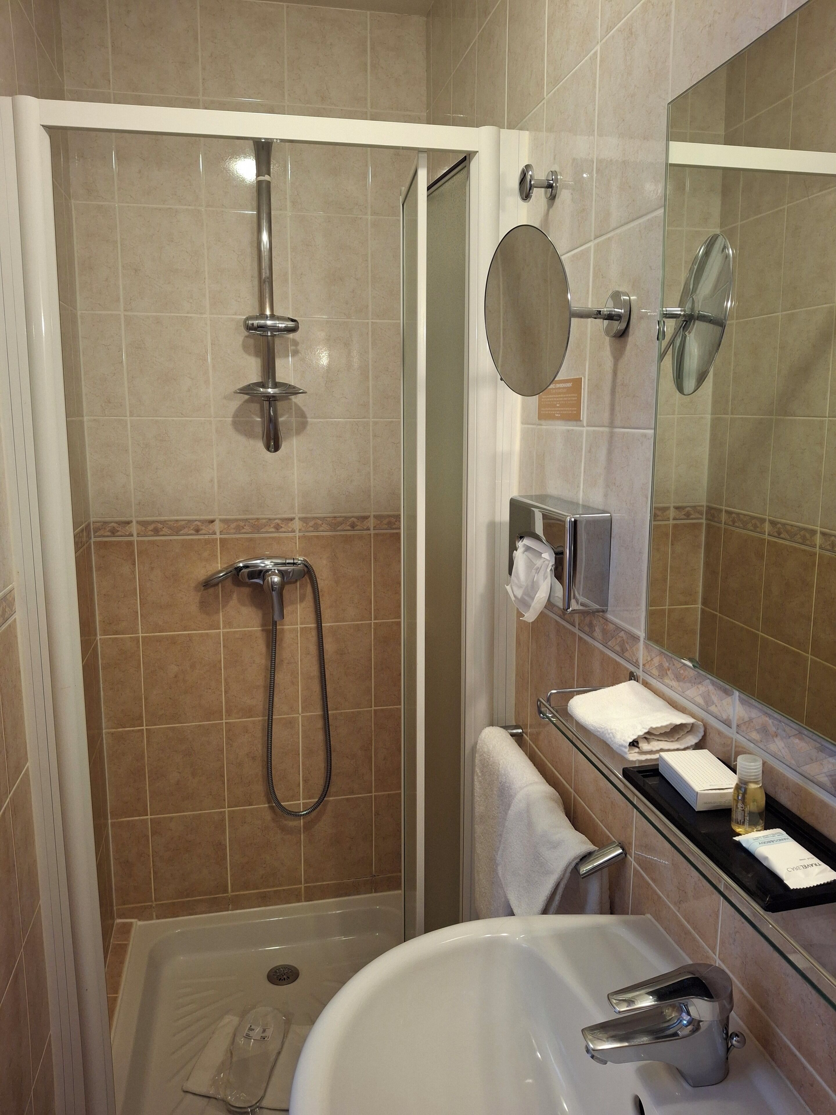 Un baño moderno con ducha acristalada, lavabo y espejo.