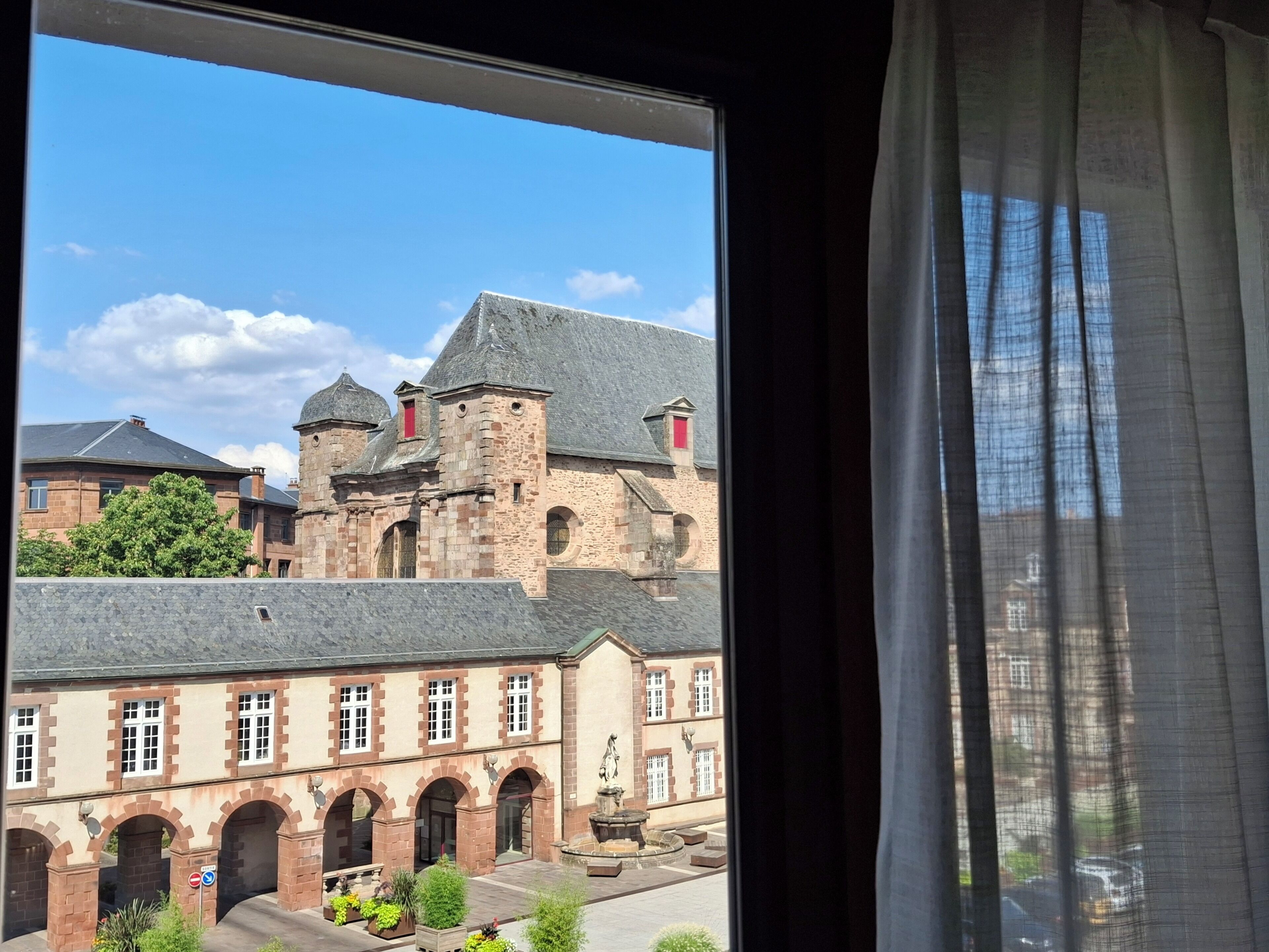 Un bâtiment historique doté d’une cour, de passages voûtés et d’une fontaine.