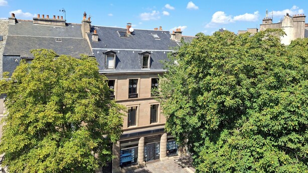 A multi-story building with a dark roof, multiple chimneys, and a storefront labeled "CENTURY 21". - Hôtel La Tour Maje (Rodez)