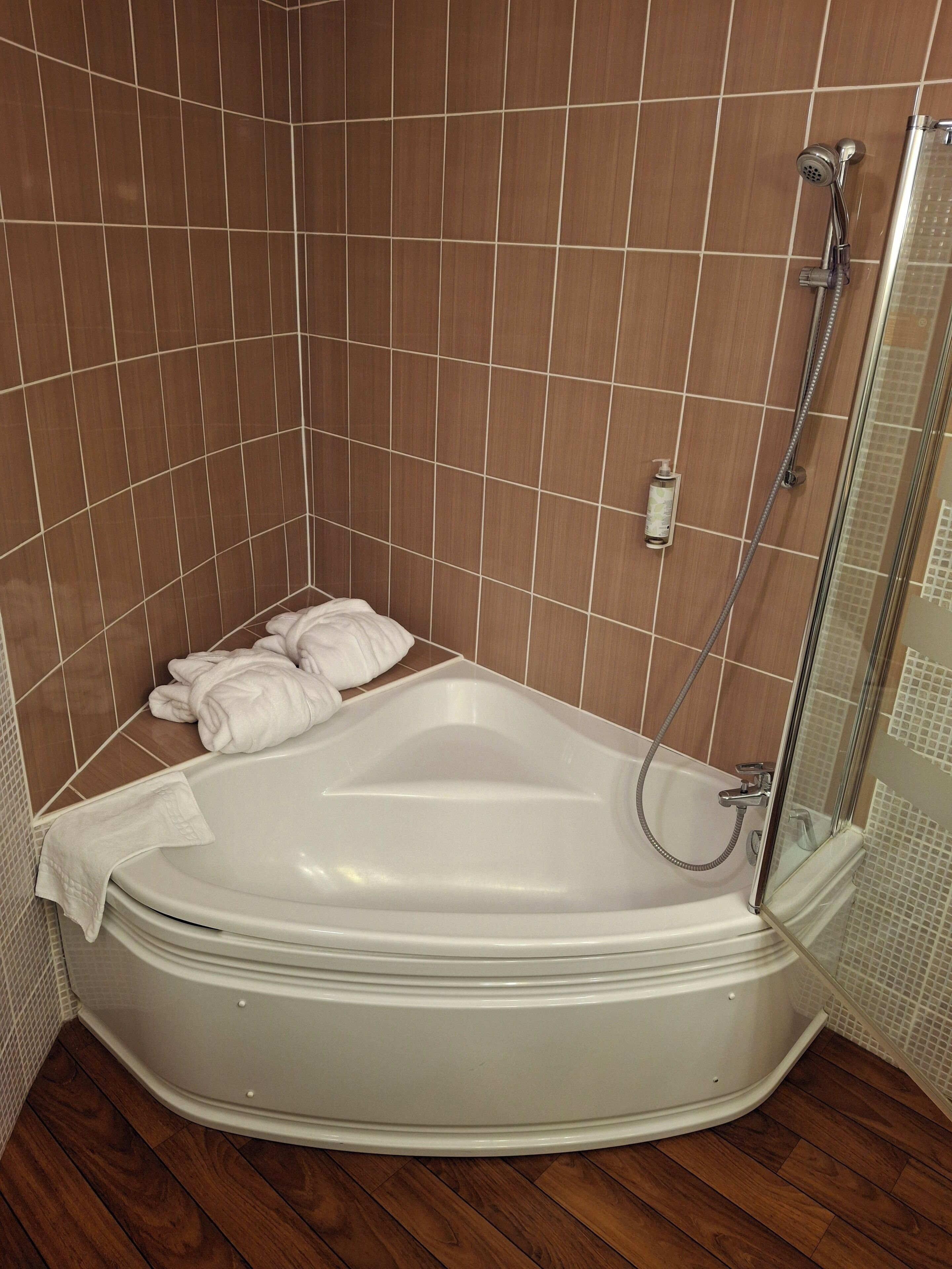 A modern bathroom with a freestanding bathtub, a glass shower enclosure, and a tiled shower wall.