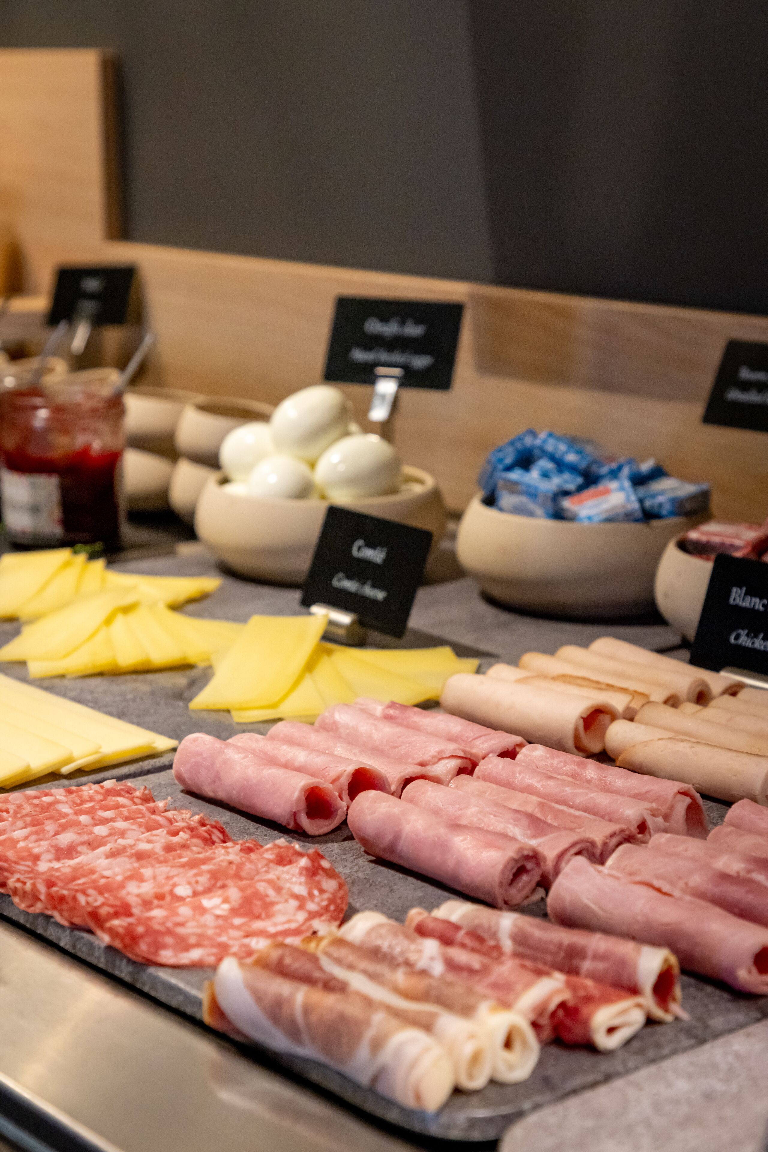 A variety of cheeses and meats displayed on a counter.