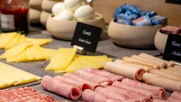 A variety of cheeses and meats displayed on a counter.