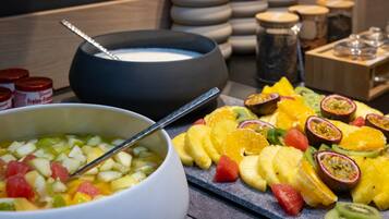 Un assortiment de fruits tropicaux présentés sur un plateau et une salade de fruits servie dans un bol.
