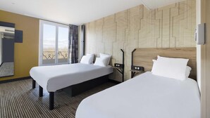 A hotel room with two beds, a large window with a view, and a wooden wall panel. - B&B HOTEL Perpignan Centre (Perpignan)