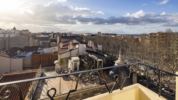 A rooftop terrace with a view of a cityscape, including buildings and a clear sky. - B&B HOTEL Perpignan Centre (Perpignan)