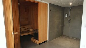 A modern bathroom with a shower, a wooden cabinet, and a glass door. - Kyriad Brest Centre (Brest)