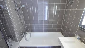 Un baño con bañera, ducha y lavamanos.