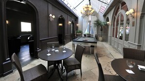 An indoor dining area with tables and chairs, a pool table, and a chandelier. - Hôtel de Bourgogne (Macon)