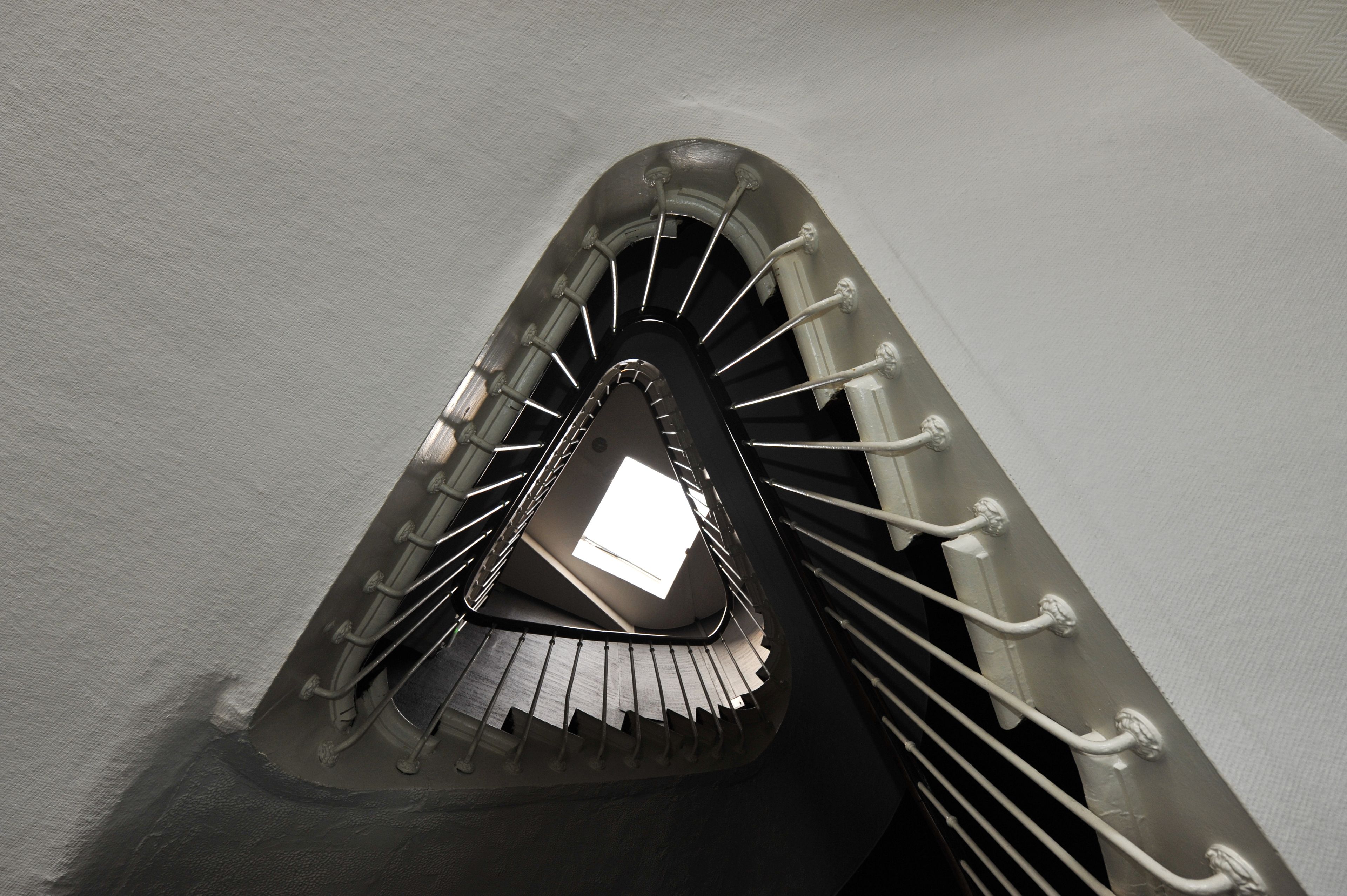 A spiral staircase with metal railings and a skylight at the top.
