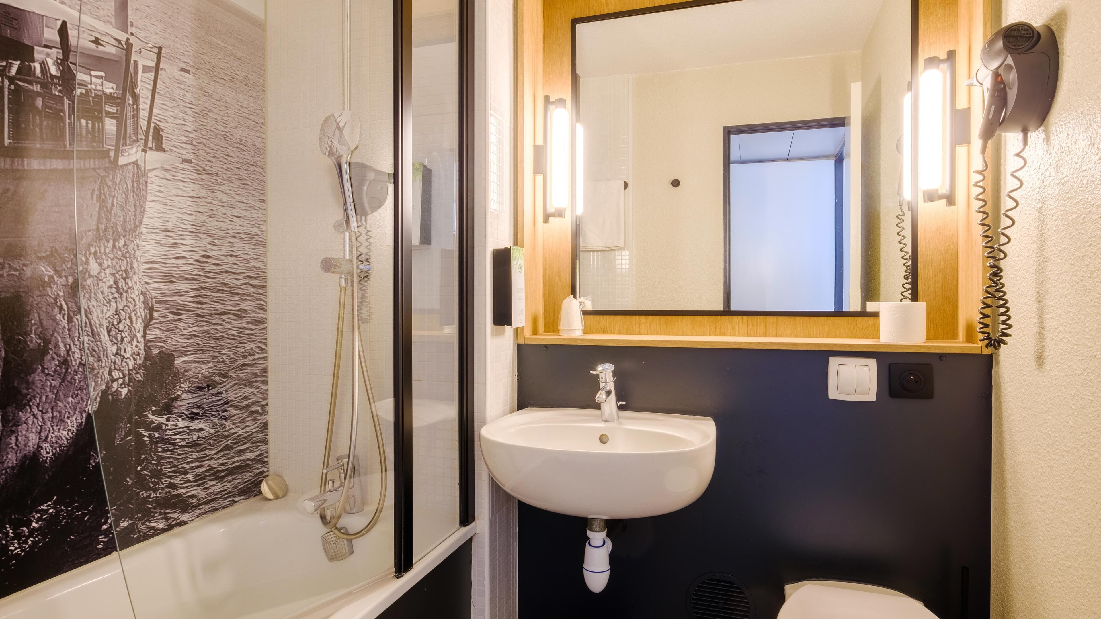 A bathroom with a bathtub, a sink, and a mirror.