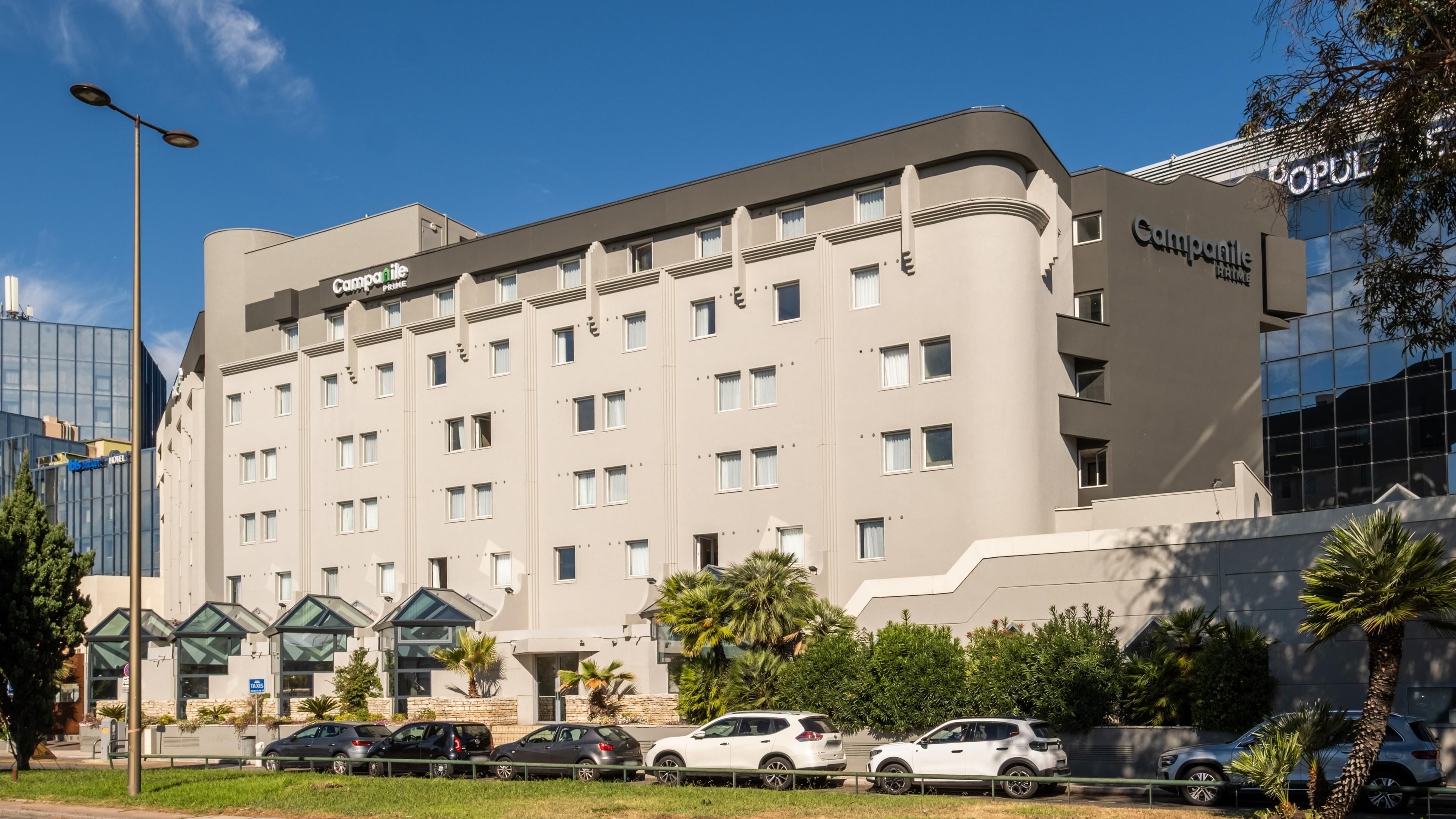 A hotel with a modern facade, multiple windows, and a flat roof.