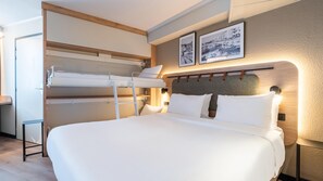 Quarto com beliche, uma escrivaninha e duas fotos emolduradas na parede.