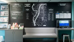 Una recepción con un mapa, una computadora y varios carteles informativos.