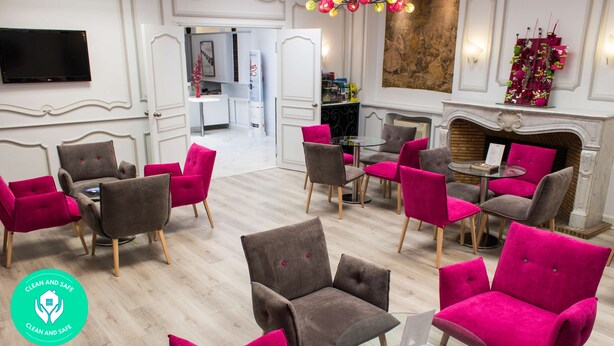 A hotel lobby with a fireplace, seating area with chairs, a television, and a dining table. - Kyriad - Tours Centre (Tours)