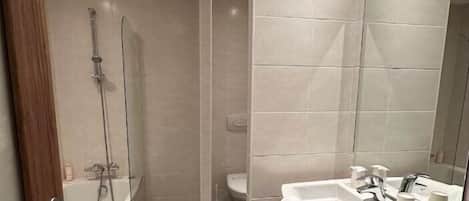 A modern bathroom with a walk-in shower, a large mirror, and a vanity with a sink and countertop.