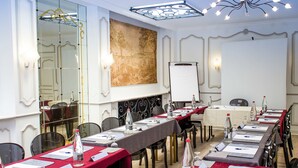 A conference room with long tables, chairs, a whiteboard, and a large decorative mirror. - Kyriad - Tours Centre (Tours)