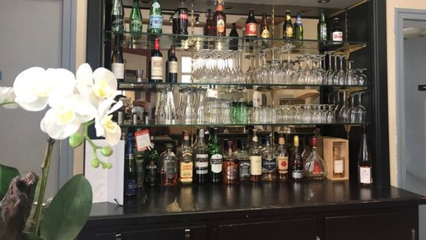 A bar area with shelves of liquor bottles and glasses.